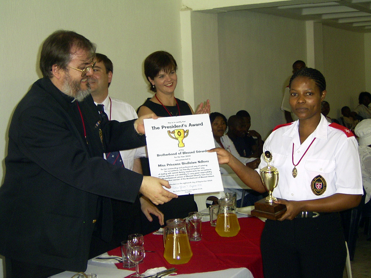 Father Gérard presenting the President’s Award certificate to Princess Sindisiwe Ndlovu, who is holding the trophy