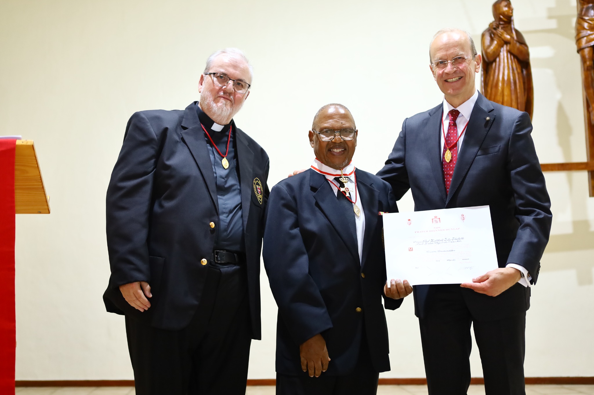 Dr Paul Zakhele Titus Thabethe with the Commander's Cross pro Merito Melitensi, Father Gérard and Grand Hospitaller Josef Blotz