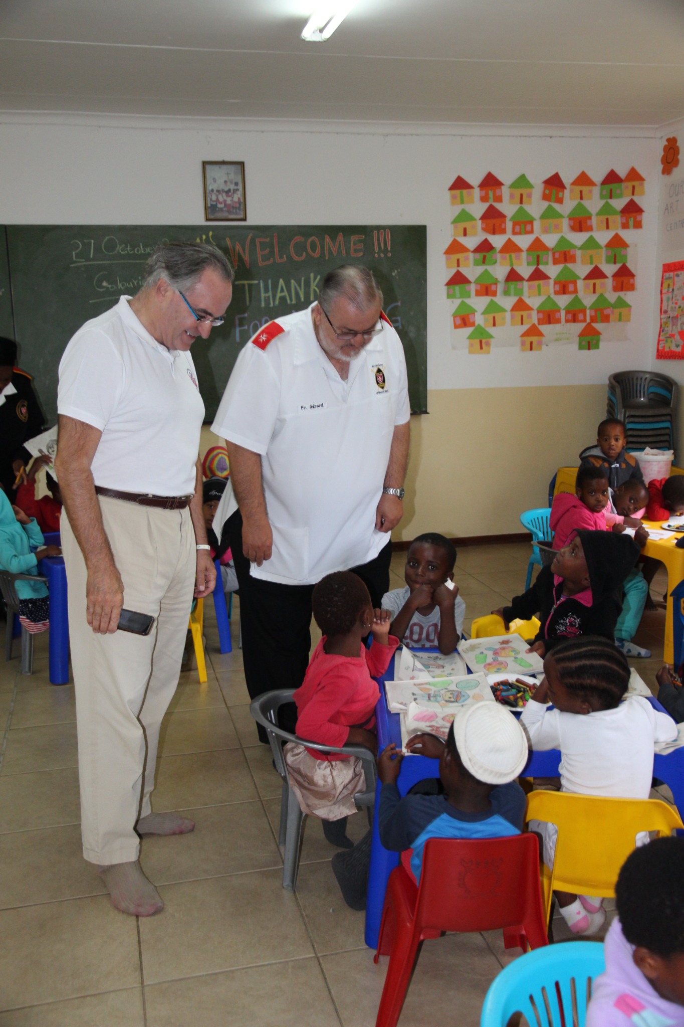 Dominique Prince de La Rochefoucauld-Montbel and Father Gérard greeting children in the Kindergarten